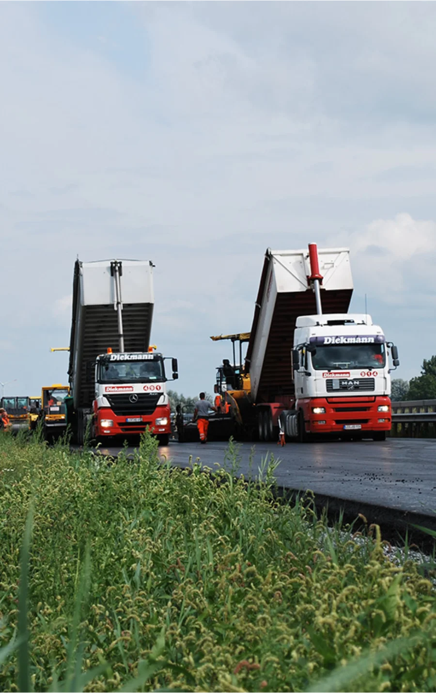 Zwei Transporter auf der Straße beim Ausleeren von Schüttgut